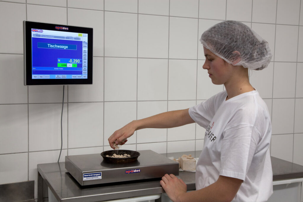 Frau wiegt etwas mit einer Tischwaage